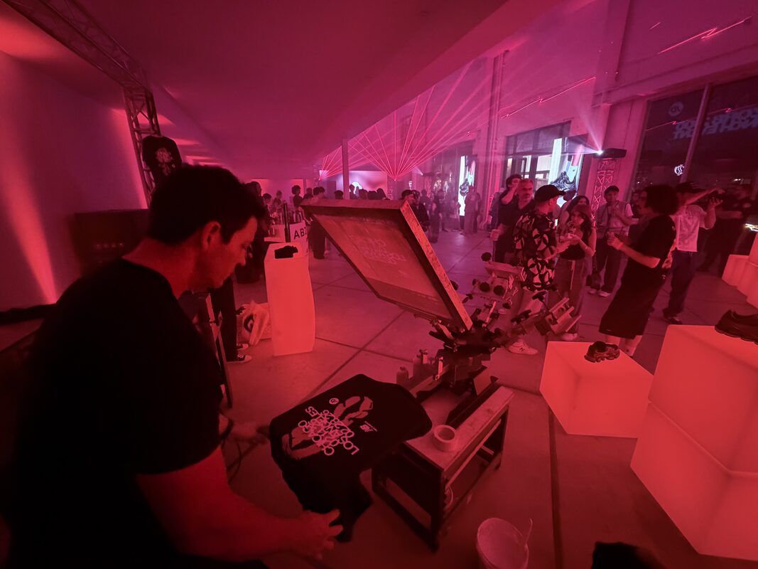 UV DTF printer running a sheet of decals at an event table